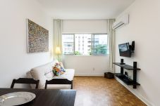 Large living room with TV, sofa and air conditioning.