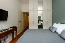 Bedroom with double bed, wardrobe and TV.