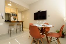 Dining room with dining table, TV and counter.